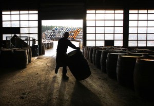 A cooper rolls a scotch whisky cask along the floor before starting the process to repair it at the Speyside Cooperage in Craigellachie